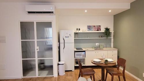 a small kitchen with a table and a refrigerator at Blend Coliving One - 2b in Ribeirão Preto