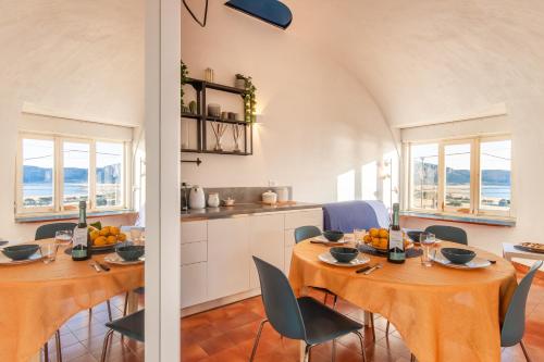a kitchen and dining room with two tables and chairs at Villa Macari Fantastic Sea View - Happy Rentals in Macari