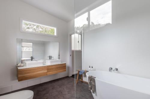 a bathroom with two sinks and a bath tub at The Local Studio - Byron Bay in Byron Bay