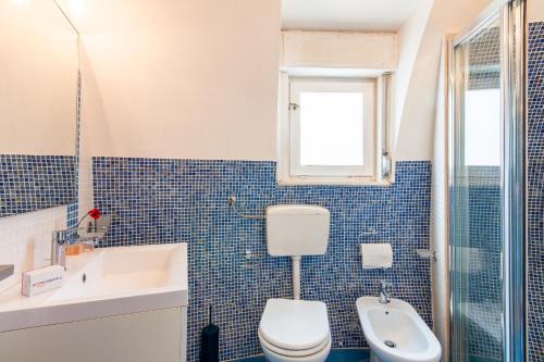 a blue tiled bathroom with a toilet and a sink at Villa Macari Fantastic Sea View - Happy Rentals in Macari