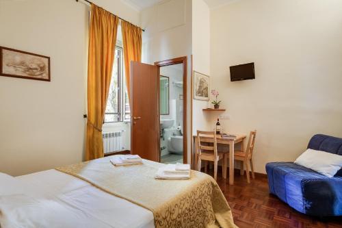 ein Schlafzimmer mit einem Bett und einem Tisch mit einem Stuhl in der Unterkunft At Rome St. Peter's in Rom