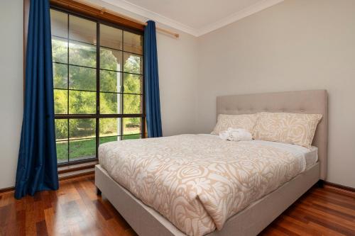 a bedroom with a bed and a large window at Seaside Getaway in Dunsborough