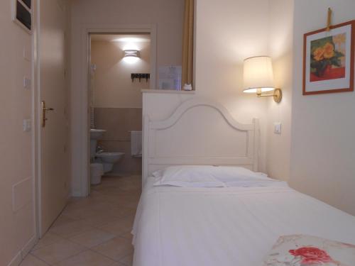 a bedroom with a white bed and a bathroom at Hotel Atlantic in Bologna