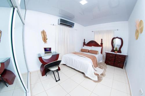 a bedroom with a bed and a desk and a mirror at el cielo en la tierra in Isabel de Torres