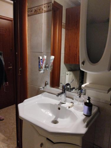 a bathroom with a white sink and a mirror at Linda's apartment in Agia Triada