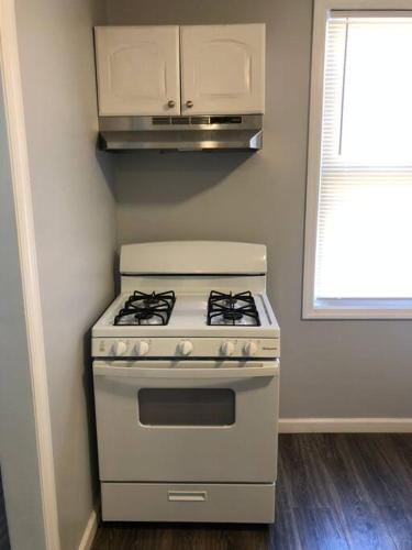 a white stove in a kitchen with a window at Private 2-bedroom with free parking and direct bus to NYC Manhattan only 2 blocks away in Linden