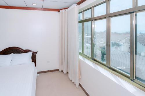 a bedroom with a bed and a large window at Phúc Đạt Hotel in Vung Tau