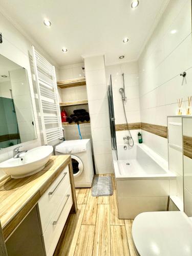 a bathroom with a sink and a toilet and a tub at Centrum Legnicy - Złotego Florena in Legnica