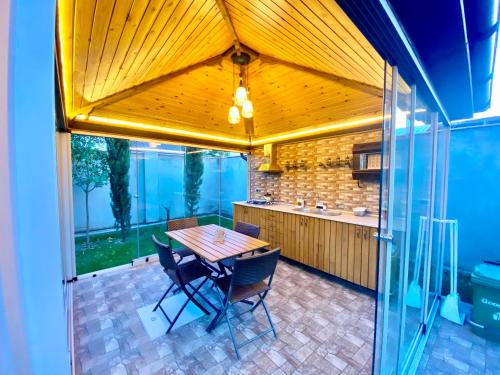 an open kitchen with a wooden table and chairs at Villa Lux in Quba in Quba
