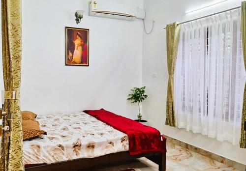 ein Schlafzimmer mit einem Bett mit einer roten Decke darauf in der Unterkunft Padmanabham in Thiruvananthapuram