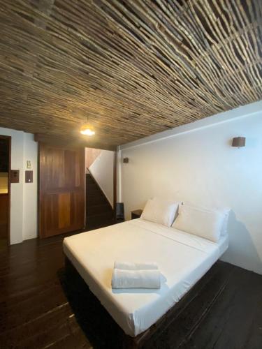 a bedroom with a large bed with a wooden ceiling at Boracay Coco Huts in Boracay