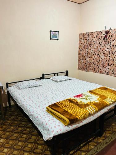 a bedroom with a bed with a blanket on it at Orchid Park Homestay in Sivasagar