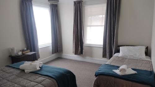 a bedroom with two beds with towels on them at The Greytown Hotel in Greytown