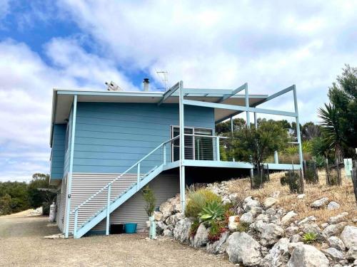 a blue house with stairs on the side of it at Dune Escape - beach tranquility in Emu Bay