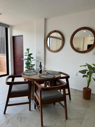 ein Esszimmer mit einem Tisch und 2 Spiegeln in der Unterkunft Nabani Condominios T1 in Santa Cruz Huatulco