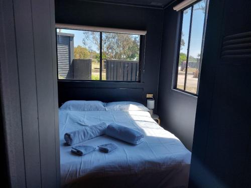 ein Schlafzimmer mit einem Bett mit zwei Kissen und einem Fenster in der Unterkunft Stawell Grampians Gate C & C Park in Stawell