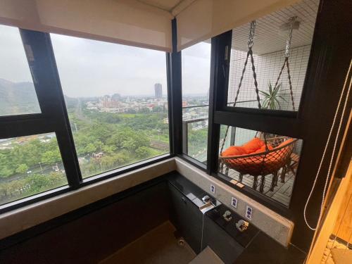a room with windows with a swing in the middle at 光嶼海溫泉海景無邊際泳池豪華套房 in Hsin-hsing