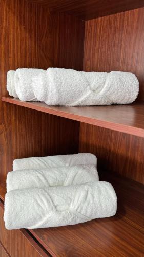 zwei Regale mit weißen Handtüchern an einer Holzwand in der Unterkunft Nabani Condominios T1 in Santa Cruz Huatulco