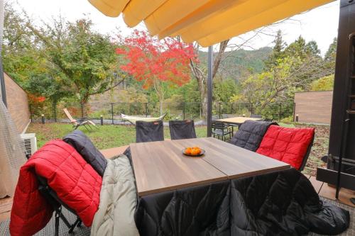 a wooden table with red cushions on a patio at SEN.RETREAT CHIKATSUYU in Tanabe