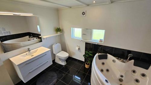un bagno con vasca, WC e lavandino di Cozy And Modern Holiday Home With All Equipment a Neder Lysabild