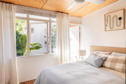 een slaapkamer met een bed en een groot raam bij The Seaport Burleigh in Gold Coast