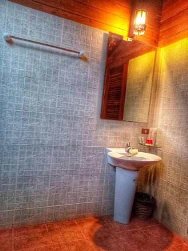 a bathroom with a white sink and a mirror at Samui Wooden Hill Resort in Lamai
