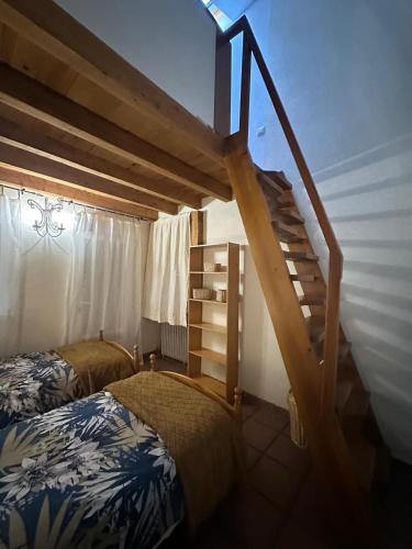 a bedroom with a staircase and a bed and a bed and a ladder at Casas Rurales La Picotilla y la Guija in Martiherrero