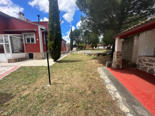 a pole in the grass in front of a house at Casas Rurales La Picotilla y la Guija in Martiherrero