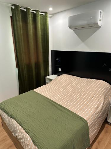 - une chambre avec un lit et un rideau vert dans l'établissement villa venus 50, au Cap d'Agde