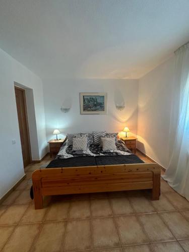 a bedroom with a wooden bed in a room at Casas Rurales La Picotilla y la Guija in Martiherrero