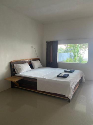 um quarto com uma cama grande e uma janela em East Lombok Dive Hotel - 3 private rooms on the beach with seaview & scuba diving center em Labuhan Pandan