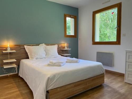 une chambre avec un grand lit avec deux serviettes dessus dans l'établissement La Maison de Charlie, à Trégastel