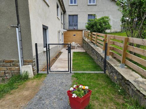 a gate with a pot of flowers in front of a house at Appartement le Crozatier in Saint-Georges