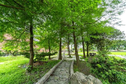 a path in a park with trees and a bench at 森堡休閒莊園 in Yilan City