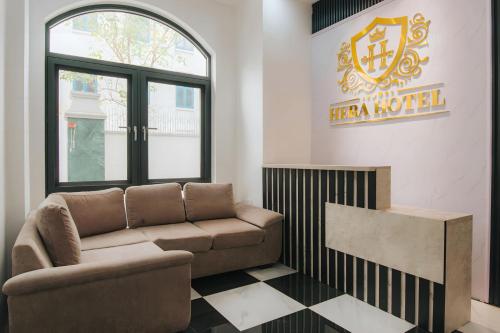 a living room with a couch and a sign for a hero hotel at Khách sạn Hera Hotel in Hà Ðông