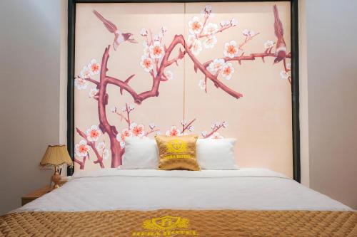 a bedroom with a large bed with a tree mural at Khách sạn Hera Hotel in Hà Ðông