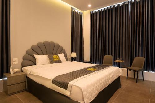 a bedroom with a large bed with a large headboard at Khách sạn Hera Hotel in Hà Ðông