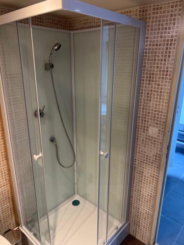 une douche avec une cabine en verre dans une salle de bain dans l'établissement Studio 4 personnes, à Mont-Dol