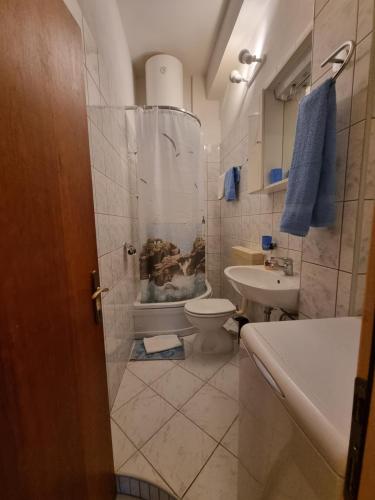 a bathroom with a toilet and a sink at Apollo - Porat 4 Apartman in Drasnice
