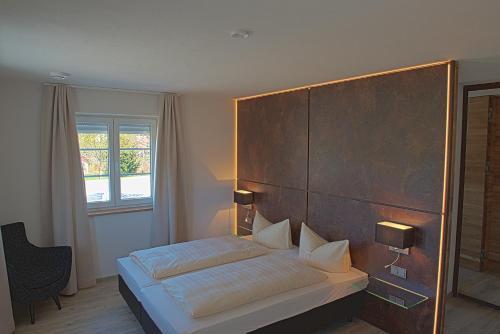 a bedroom with a bed with a wooden headboard at Truschwende 4 in Bad Wurzach