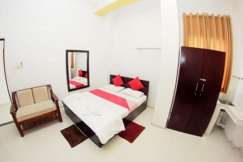 een slaapkamer met een bed, een spiegel en een stoel bij skyline villa in Adawikanda