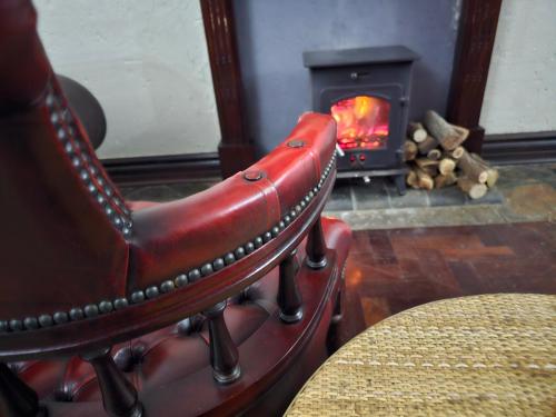 a red leather chair in front of a fireplace at Castle Home in Centurion