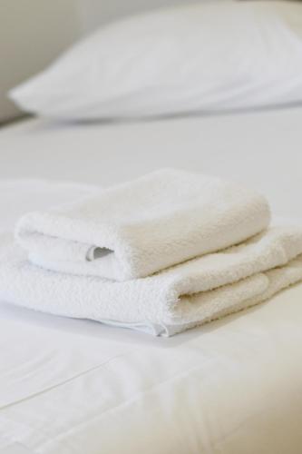 three white towels stacked on top of each other at 4 Seasons apartments in Himare