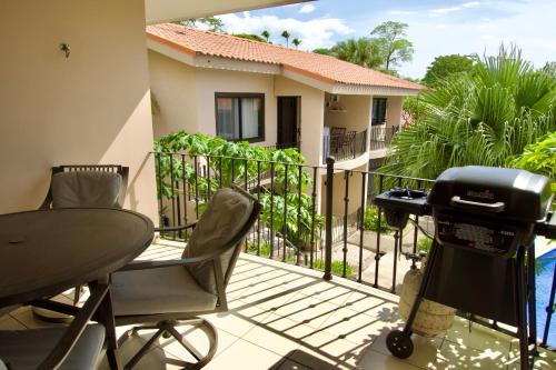 a balcony with a grill and a table and chairs at Coral Reef Condo in Coco