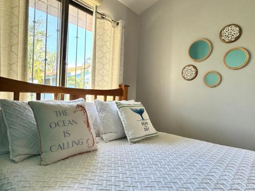 a bedroom with a bed with pillows and a window at Happy Oasis Second Floor Condo With Terrace in Coco
