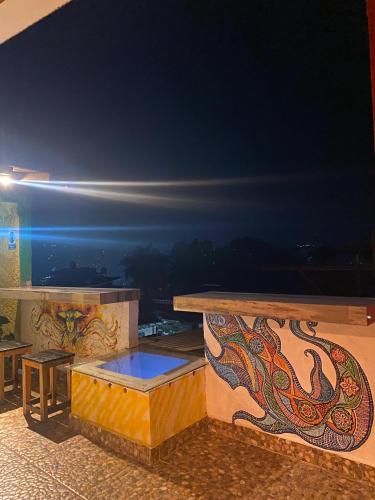 a balcony with a bench and a table with a view at Hostal el Alebrije in Valle de Bravo