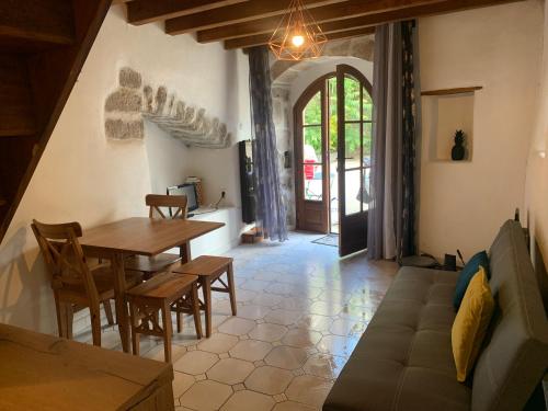 un salon avec une table et un canapé dans l'établissement Ruoms Petite Maison 3* centre-village, à Ruoms