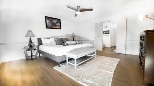a white bedroom with a bed and a table at Casa Grande Luxur in Overland Park