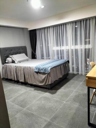 a bedroom with a large bed in front of a window at nice apartment with city view at Grand Jati Junction in Medan