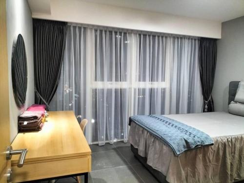 a bedroom with a bed and a desk and a window at nice apartment with city view at Grand Jati Junction in Medan
